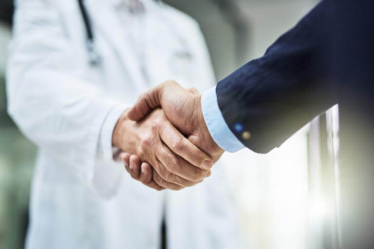 close up of cancer specialist and patient shaking hands